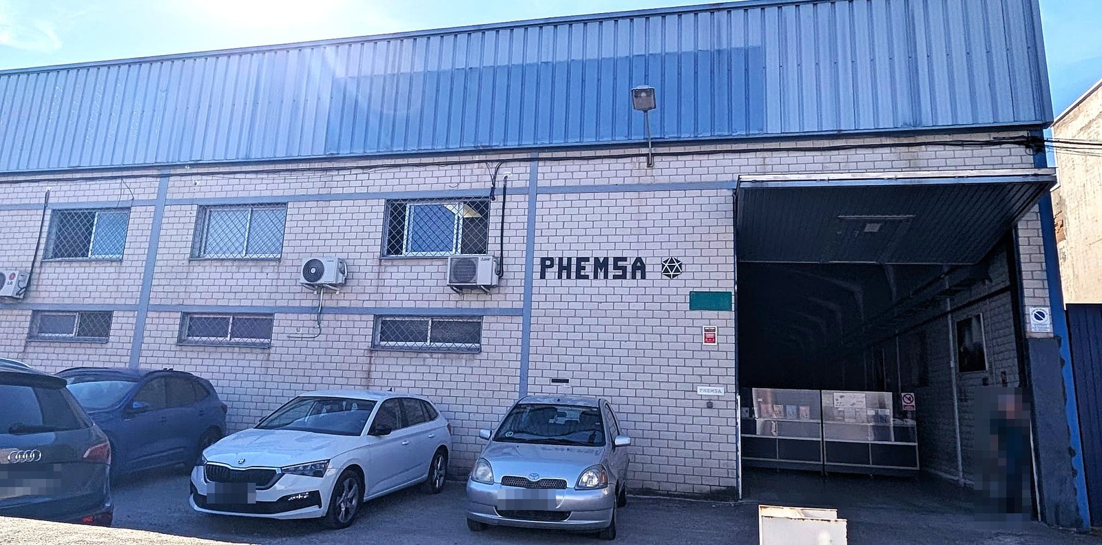 Fachada del almacén de Phemsa con el rótulo y el portón de entrada
